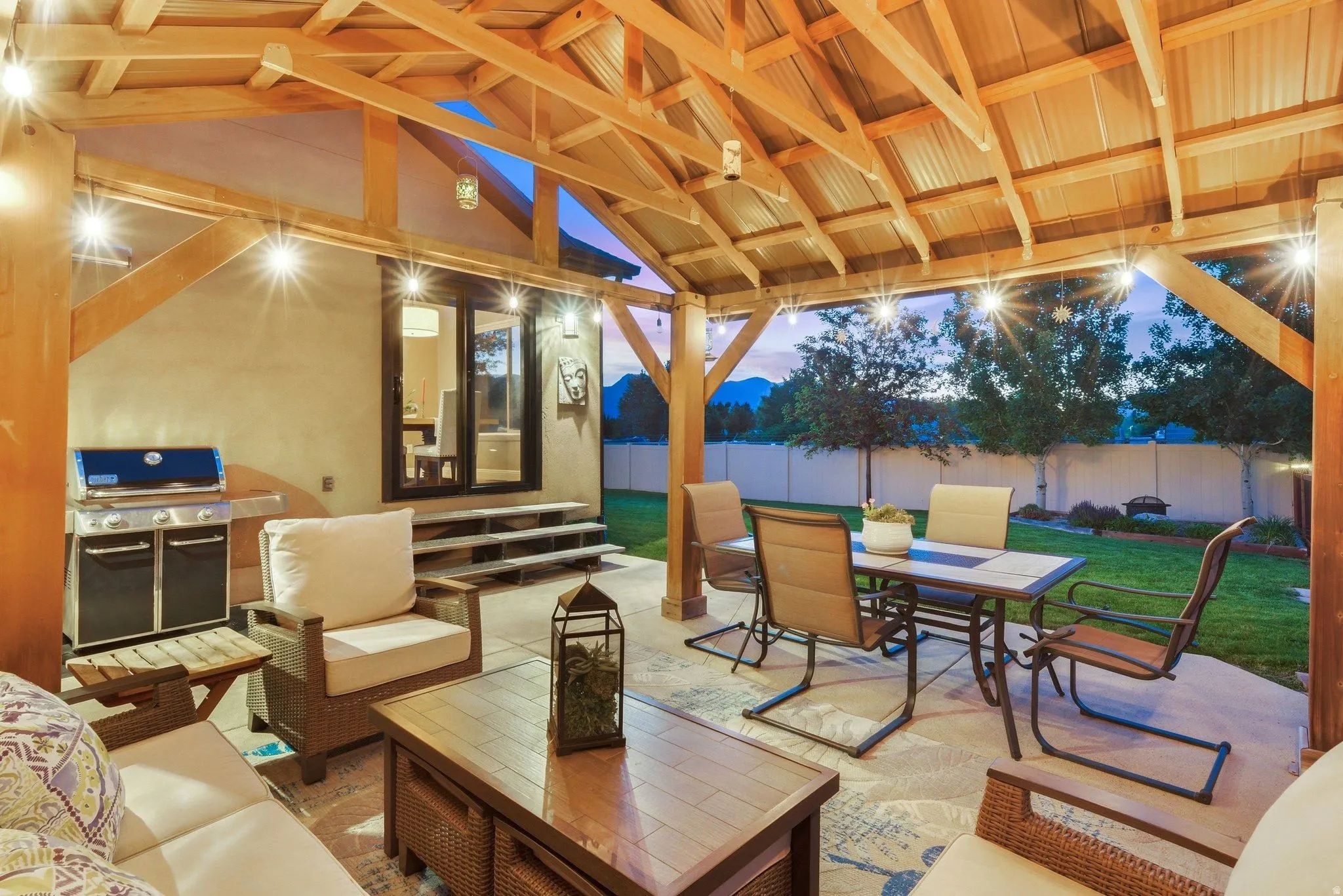 Covered patio featuring an exposed wood beam ceiling with string lighting
