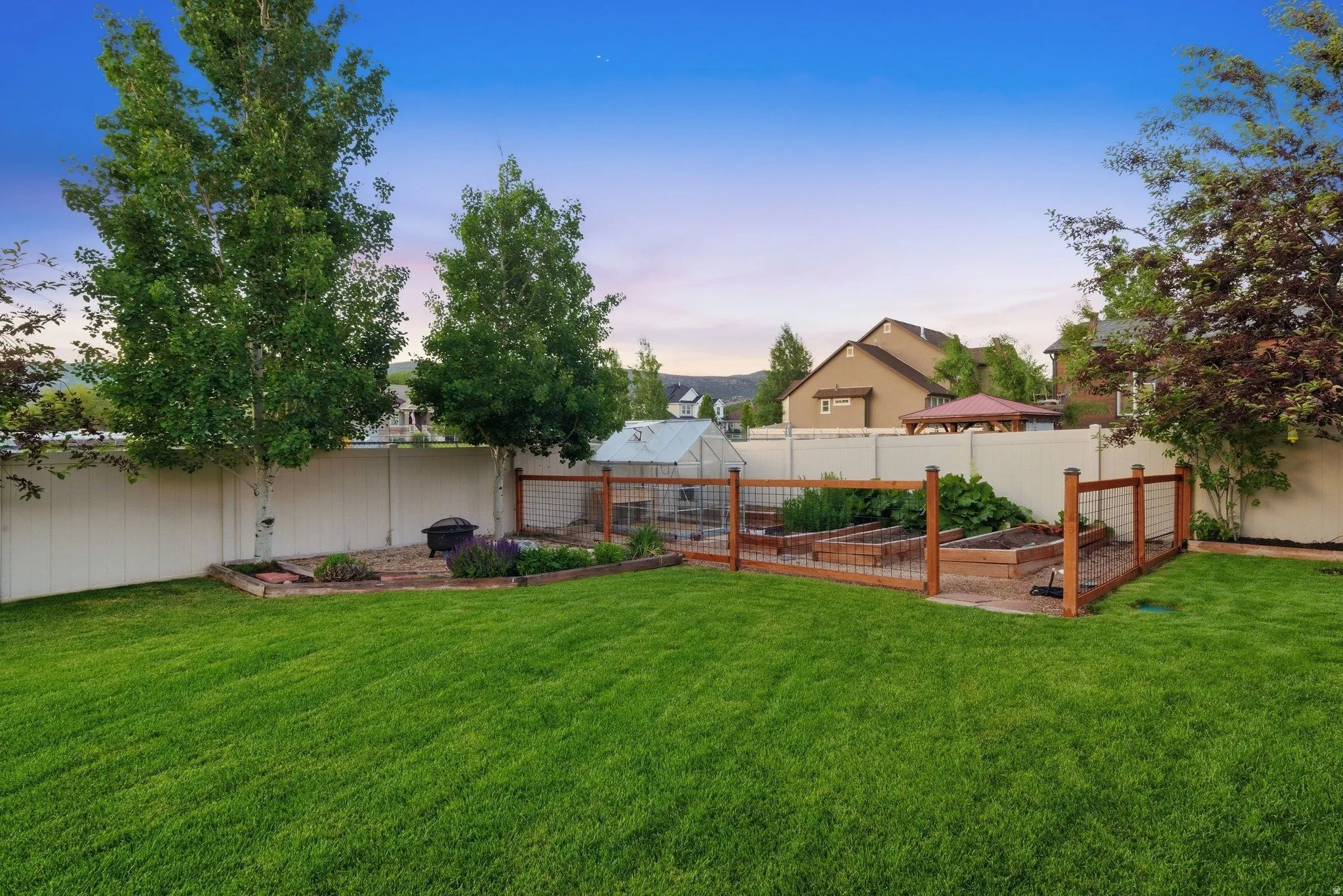 Manicured lawn with a white privacy fence