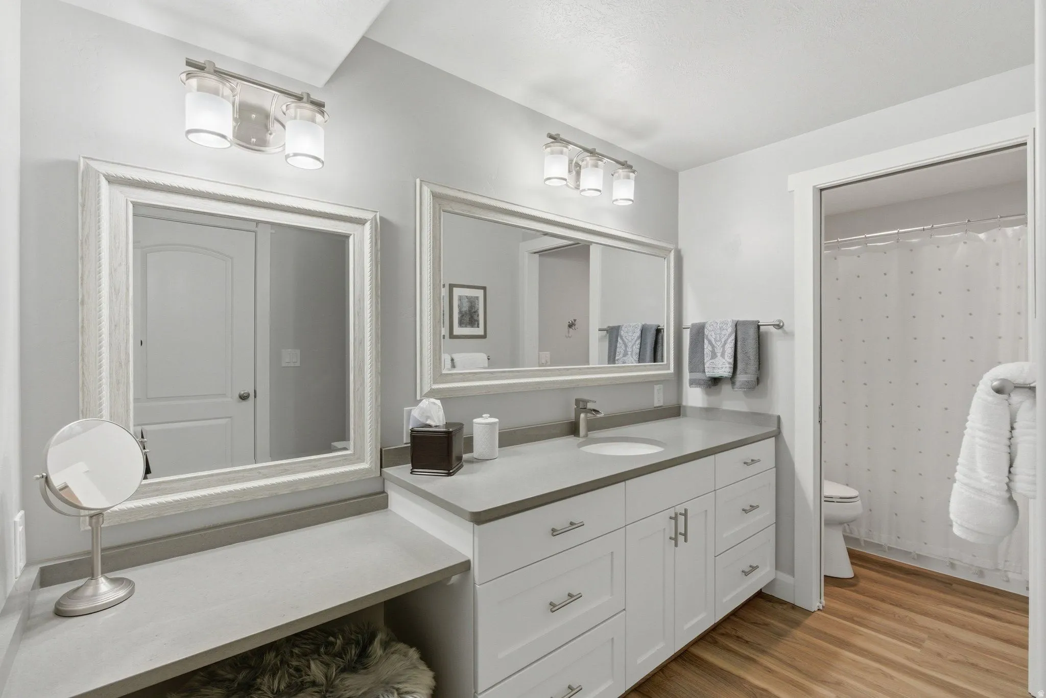 Bathroom featuring a double vanity with white cabinetry, light gray countertops, and brushed nickel hardware