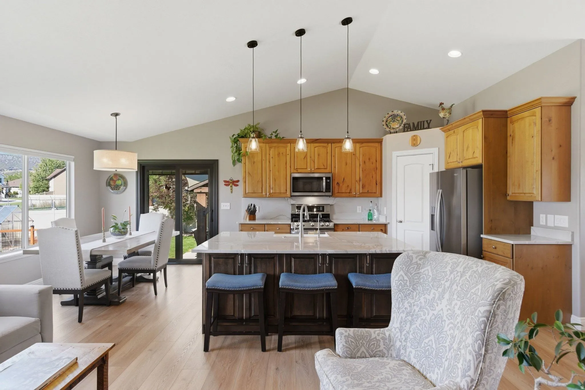 Open-concept living area featuring vaulted ceilings and light wood-finish flooring