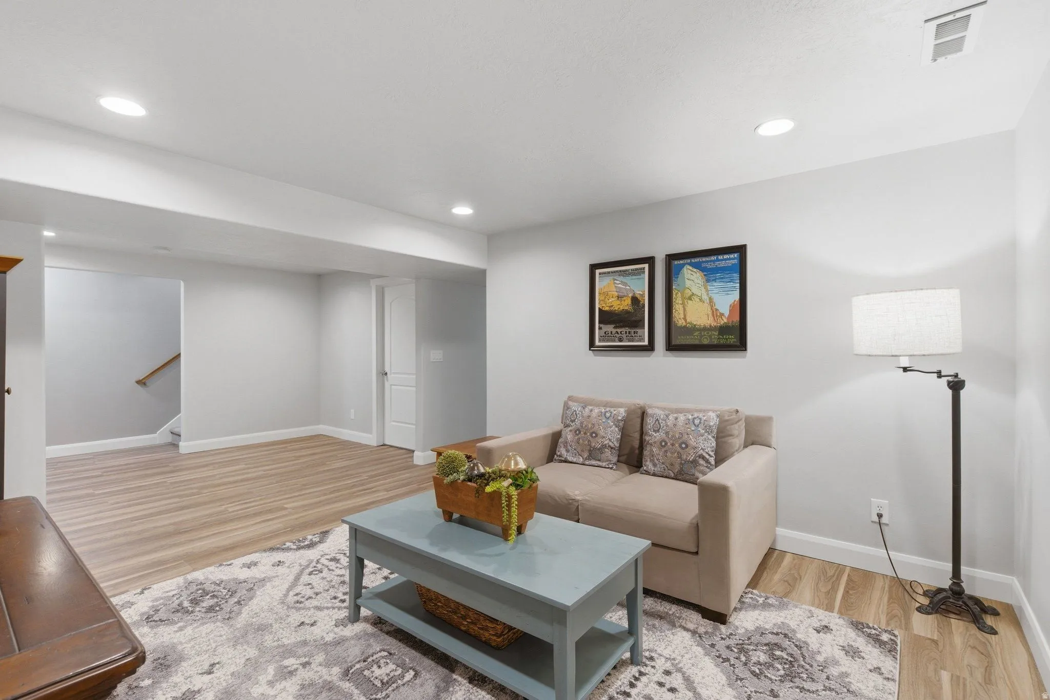 Spacious living area featuring recessed lighting, wood-finish flooring, and light gray wall tones