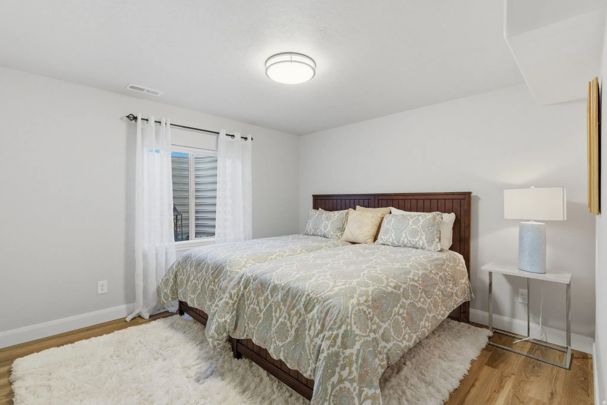 Wood-finish flooring, white baseboards, and a neutral wall color complement the room's design