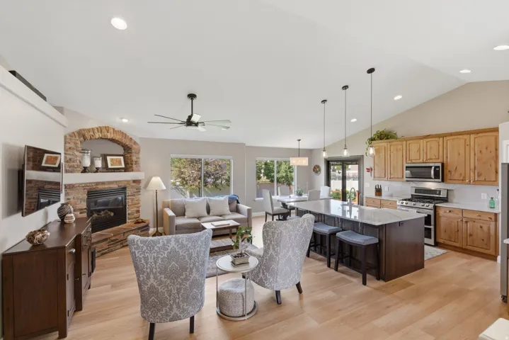 Open-concept living space featuring wood-finish flooring and vaulted ceilings