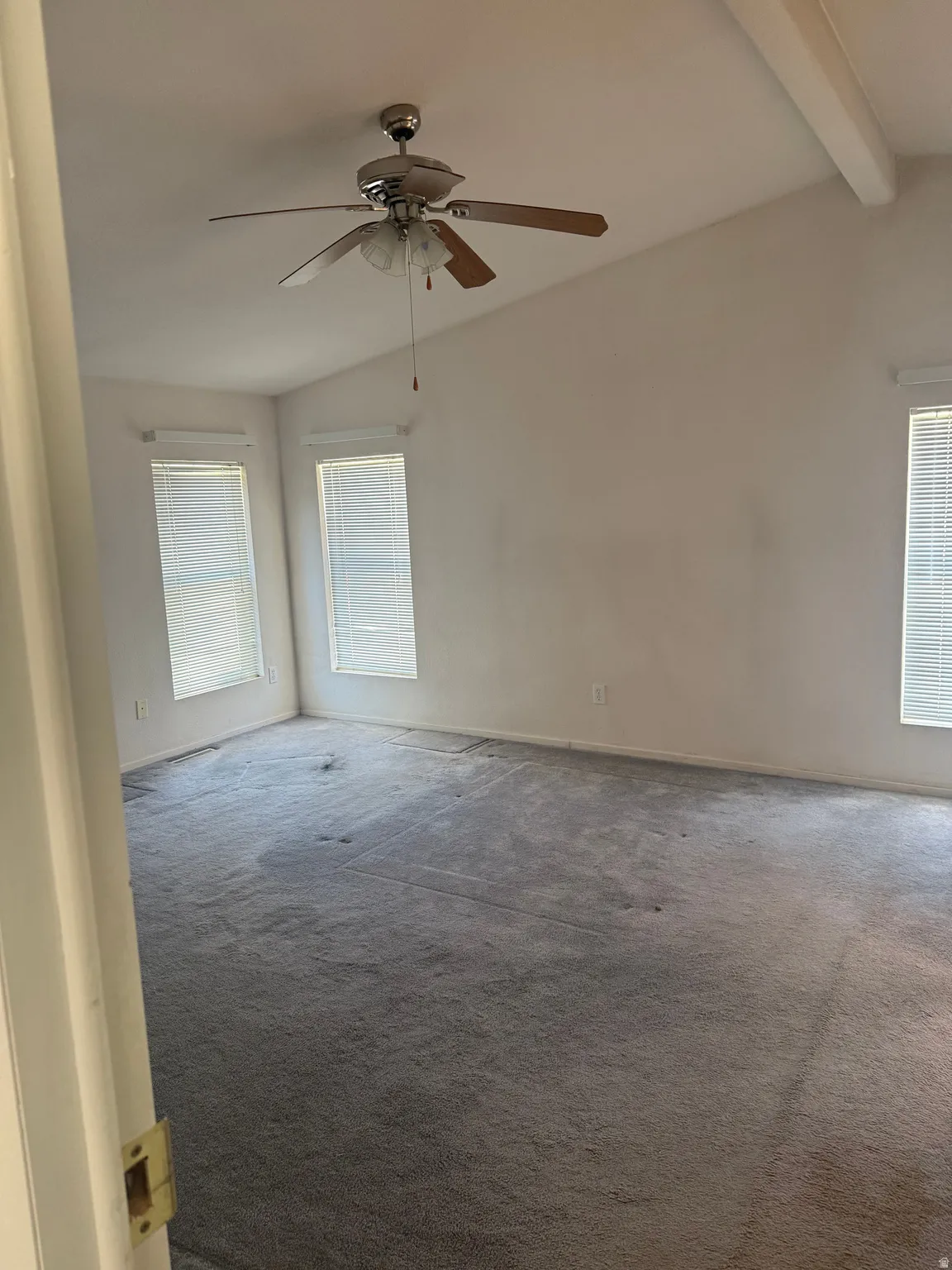 Spacious master bedroom with vaulted ceilings and a ceiling fan
