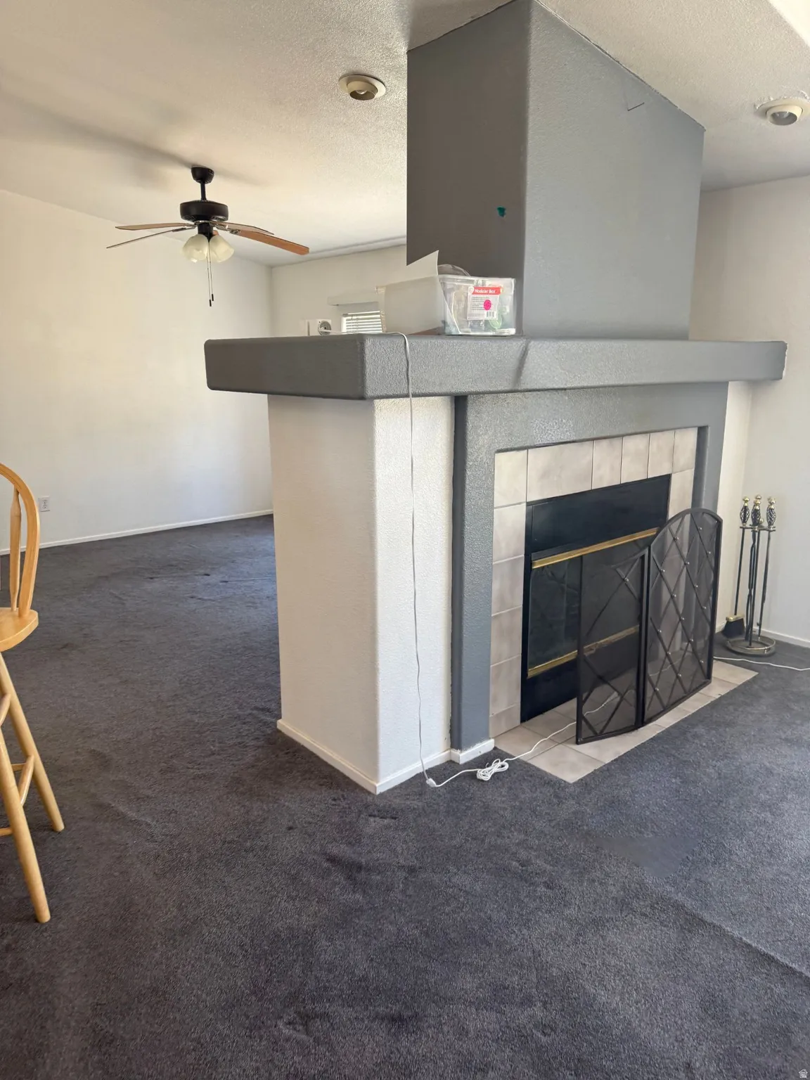 Central fireplace featuring a tile surround and hearth