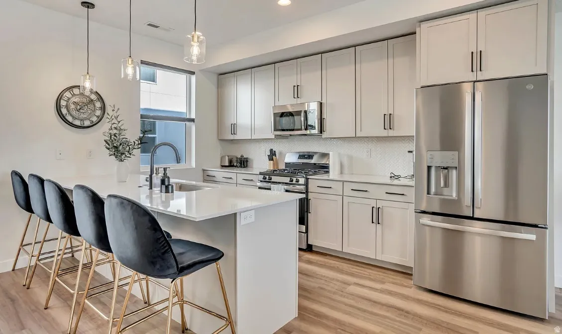 Modern kitchen featuring light wood-finish flooring and white walls