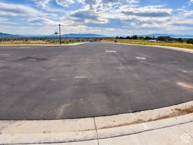 Paved street with concrete curbing, offering distant mountain and water scenery