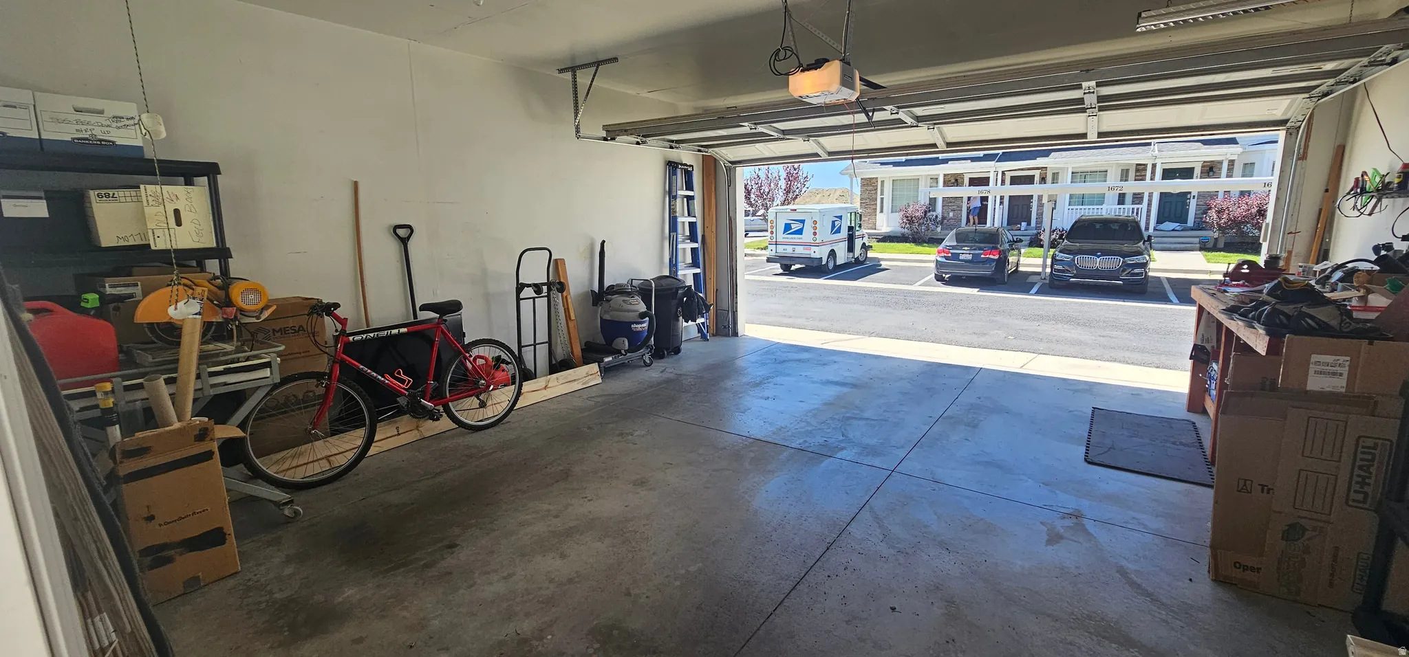 Spacious garage featuring a concrete floor, painted walls, and an automatic overhead door