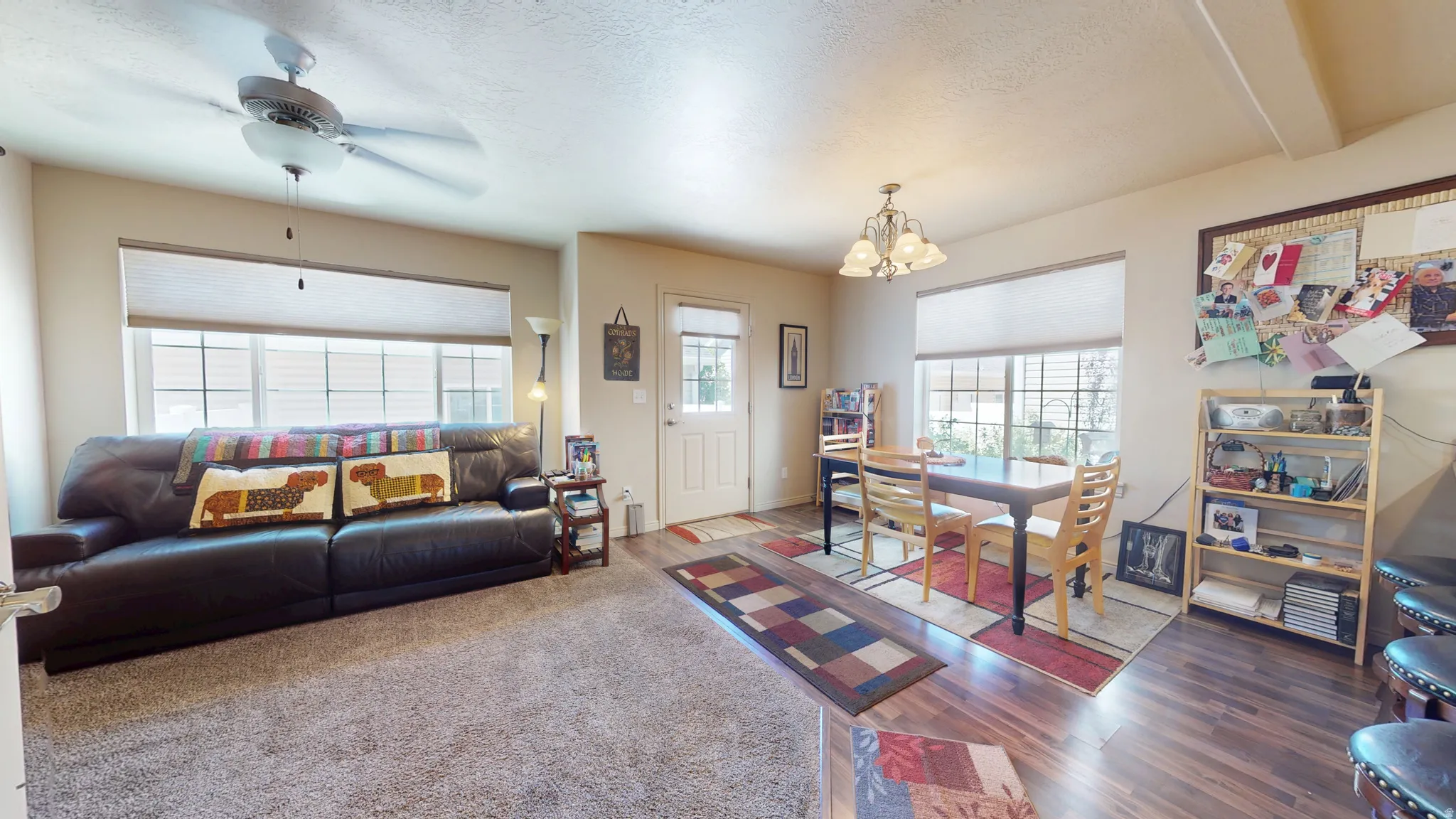 Open-concept living space with neutral paint, plush carpet, and wood-finish flooring