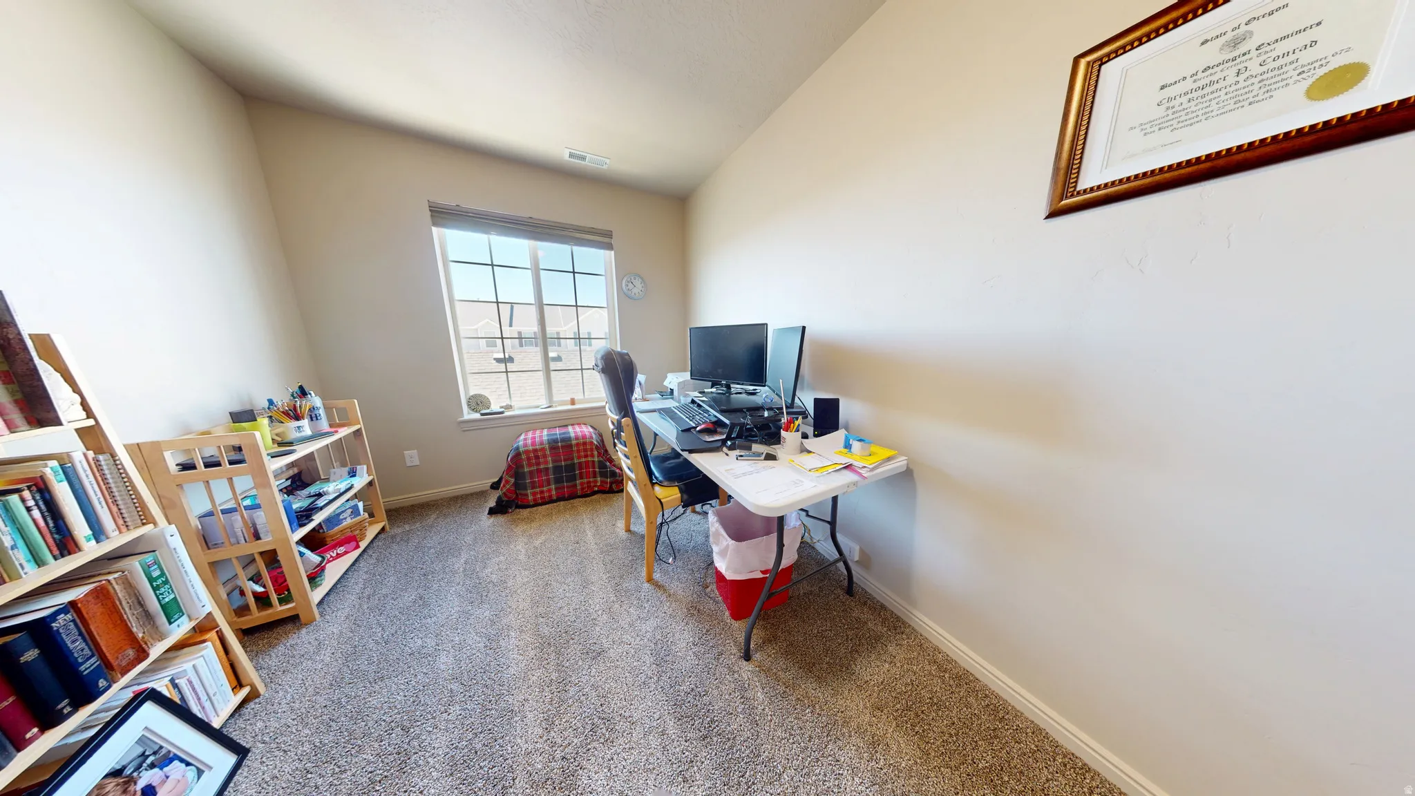 Carpeted room with a large window and light-toned walls