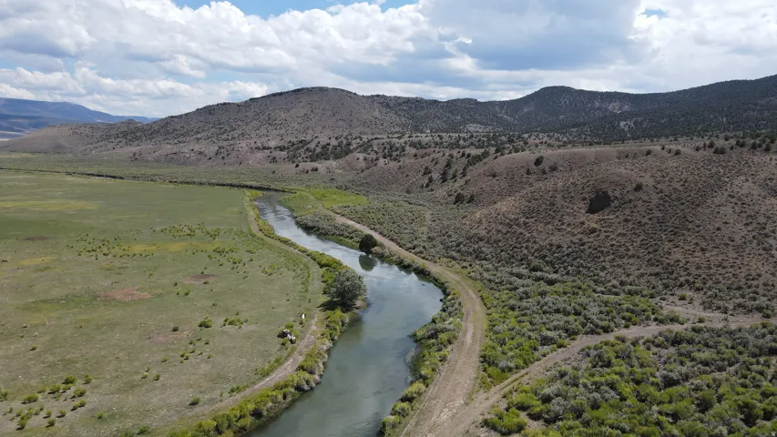 Winding river featuring natural banks and adjacent land