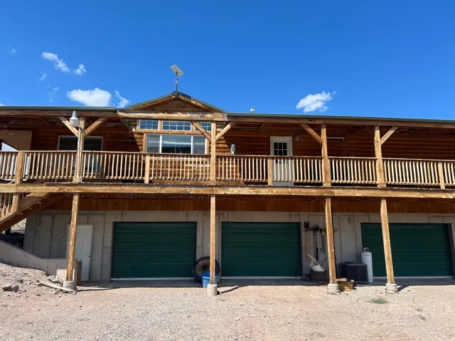 Log cabin-style residence featuring a full-width upper-level deck with wood railing
