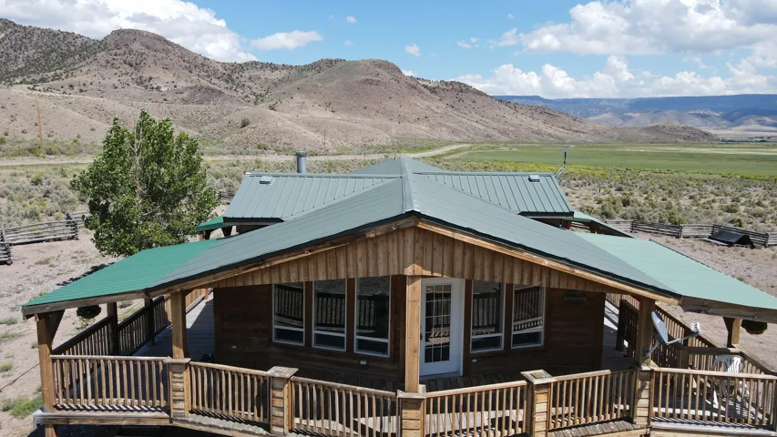 Wood-sided dwelling featuring a covered wrap-around porch with wooden railings