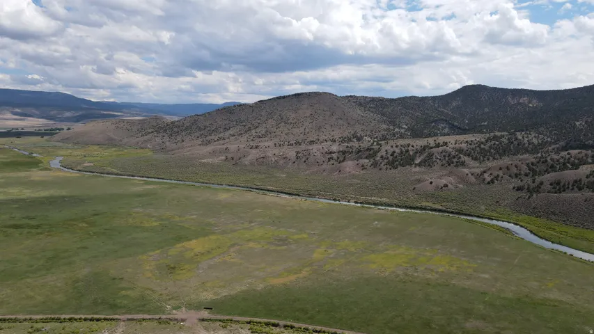 Expansive natural landscape featuring a winding river and lush green fields