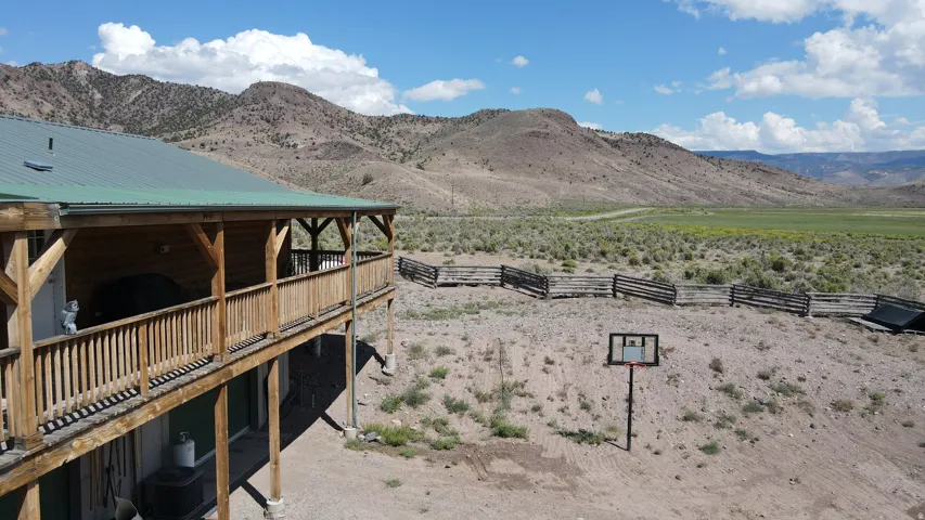 Wood-sided home with a green metal roof, featuring a full-length covered balcony