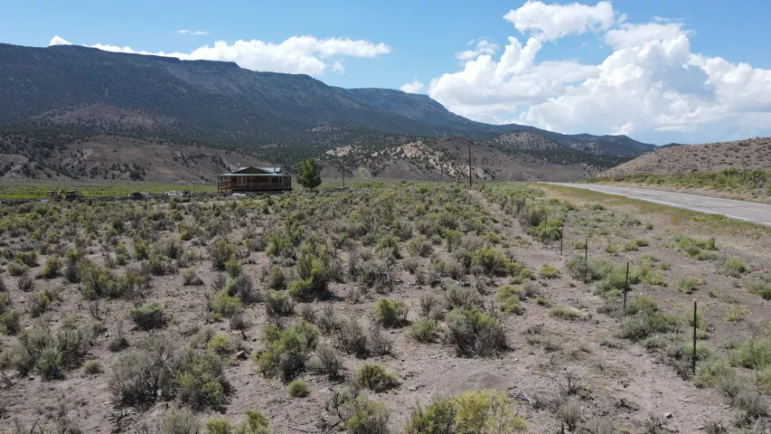Expansive natural landscape with a distant log cabin structure