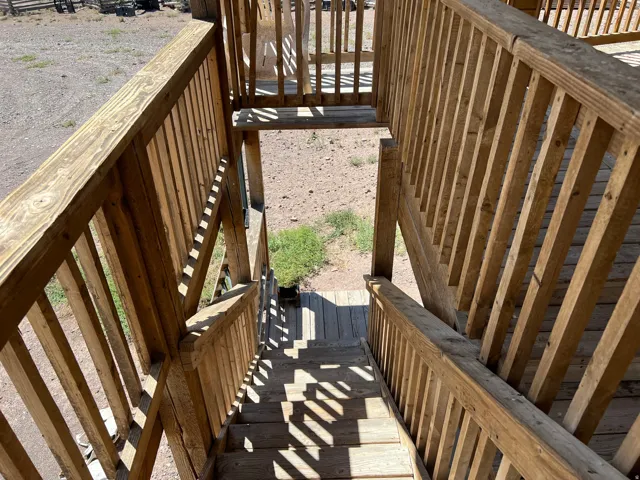 Multi-level wood deck structure with slatted railings and wooden steps