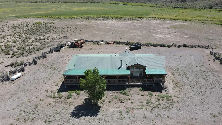 Ranch-style residence featuring a prominent green metal roof, full perimeter deck, and a single dormer window