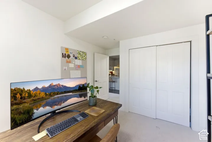 Versatile room featuring white walls, light-colored carpet, and a built-in closet with bi-fold doors