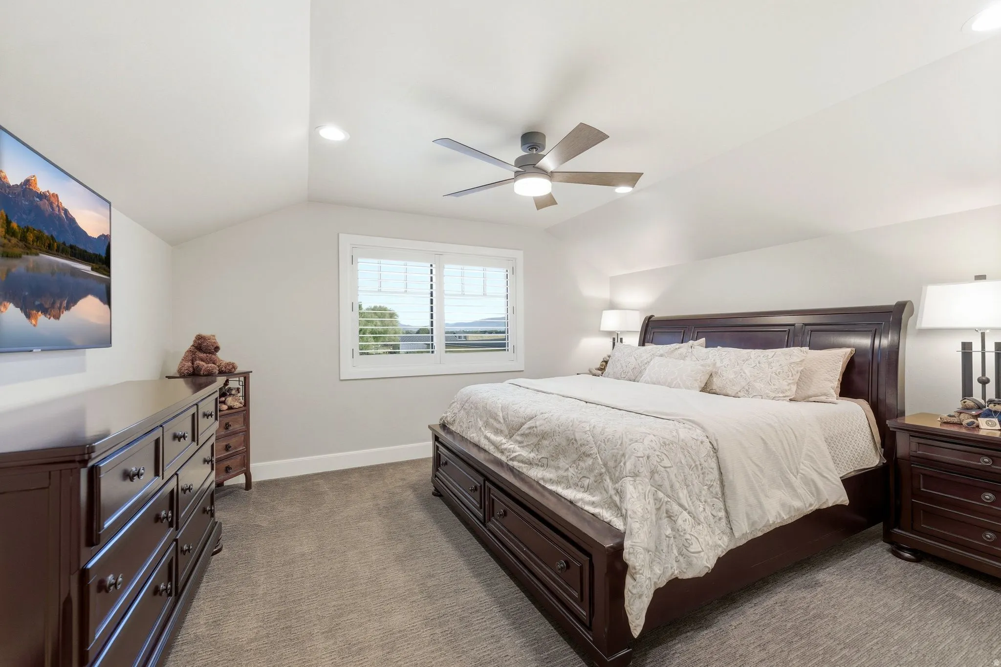 Spacious room featuring vaulted ceilings, recessed lighting, and a ceiling fan