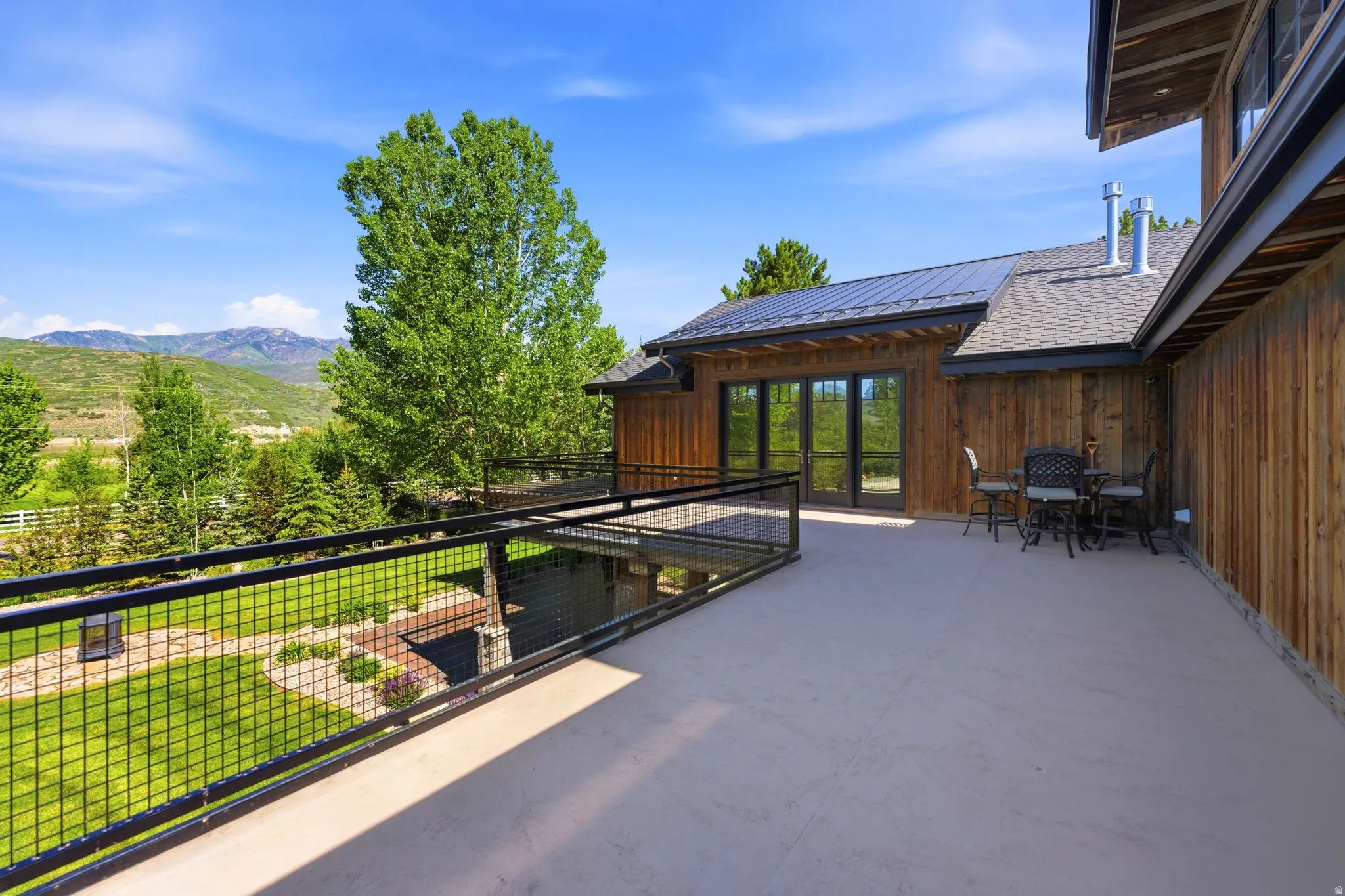 Expansive outdoor deck featuring a metal railing and mountain scenery
