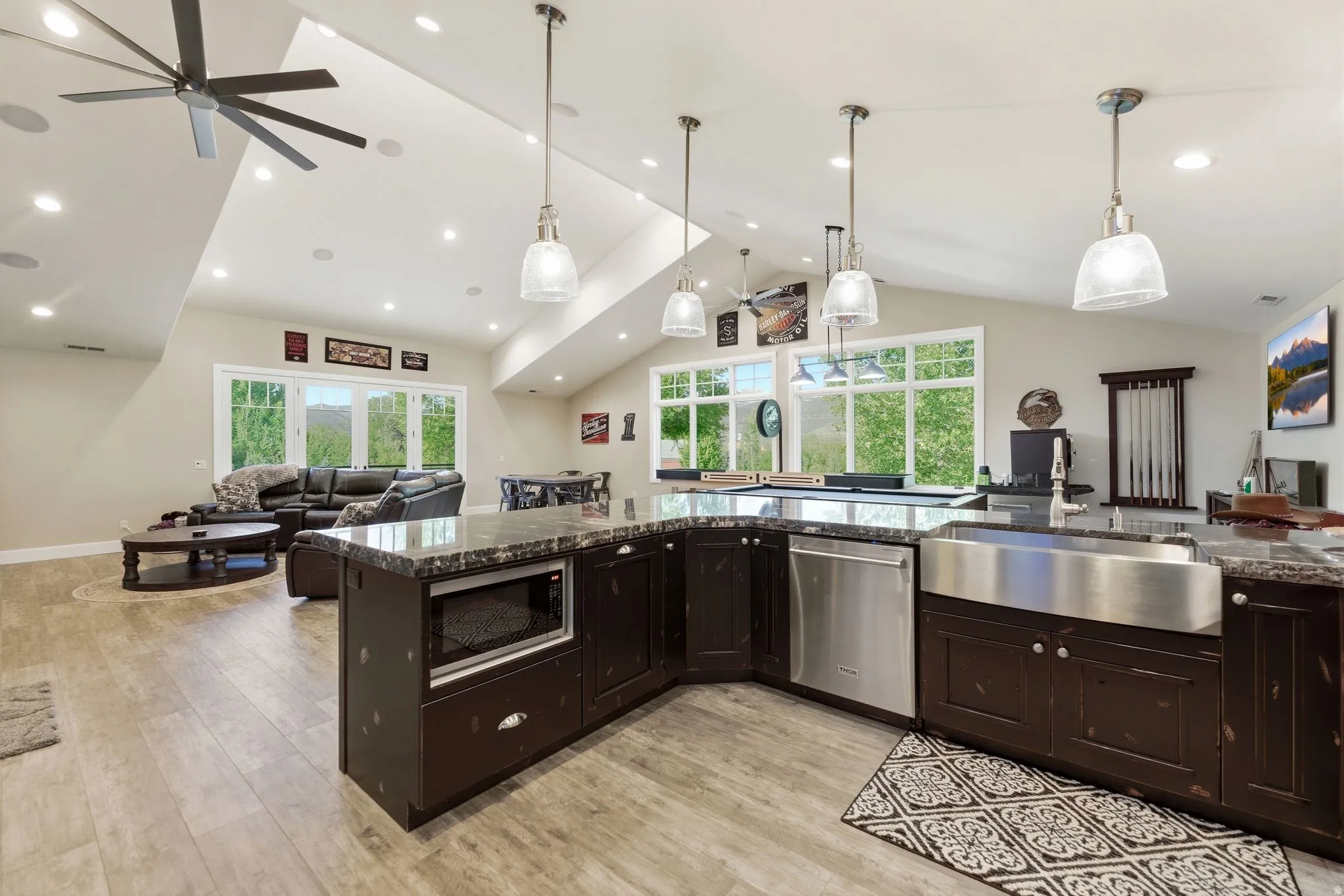 Spacious kitchen island featuring a farmhouse sink, stainless steel dishwasher, and built-in microwave