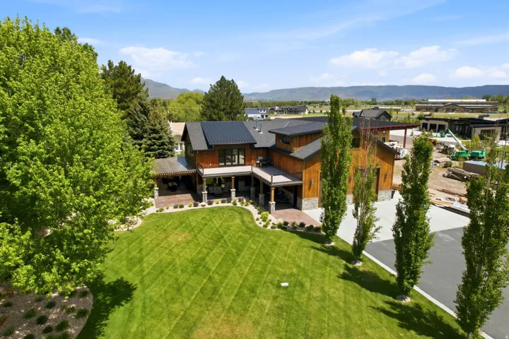 Contemporary property featuring extensive wood siding, a dark metal roof, and a stone facade