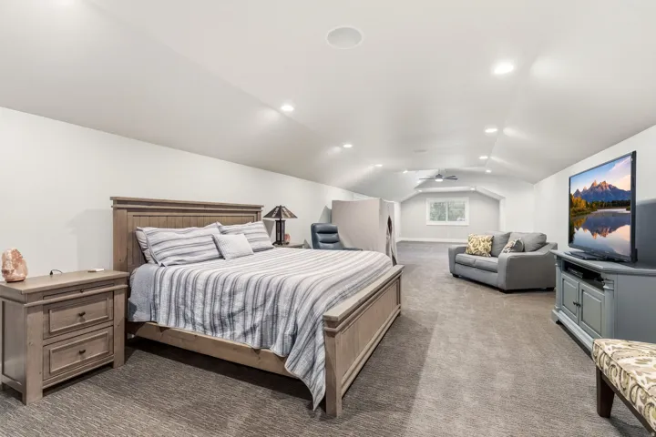 Spacious room featuring vaulted ceilings, recessed lighting, and soft gray carpeting
