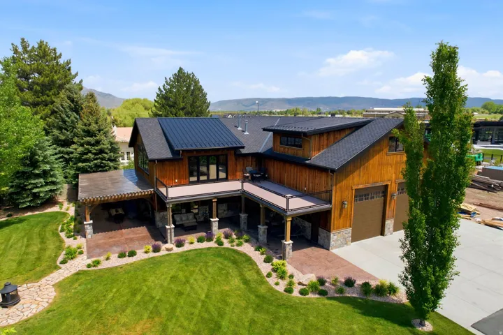 Contemporary residence featuring wood siding and a black metal roof
