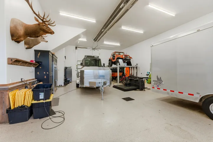 Spacious garage featuring high ceilings, fluorescent lighting, and durable epoxy flooring