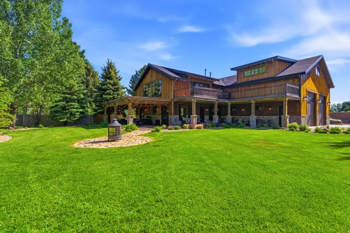 Expansive backyard with a lush lawn and mature trees