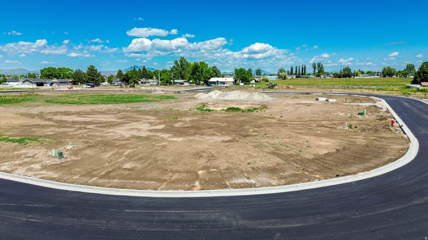 Expansive cleared lot with new asphalt paving and concrete curbing