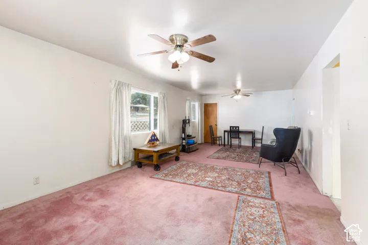 Bright interior space featuring a window with natural light, two ceiling fans, and a solid core door