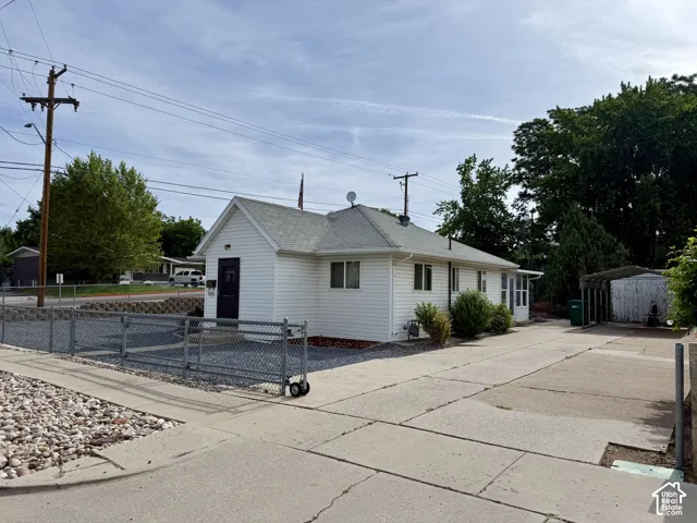 White siding exterior with a dark entry door and white trim