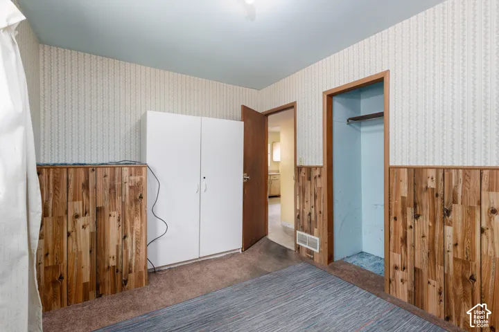 Interior room featuring wood paneling, patterned wallpaper, and light blue ceiling