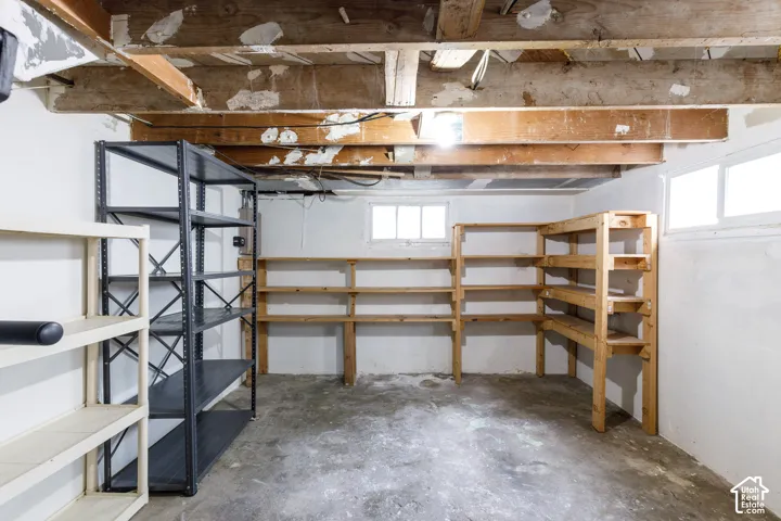 Unfinished basement featuring exposed wood ceiling joists and a concrete floor