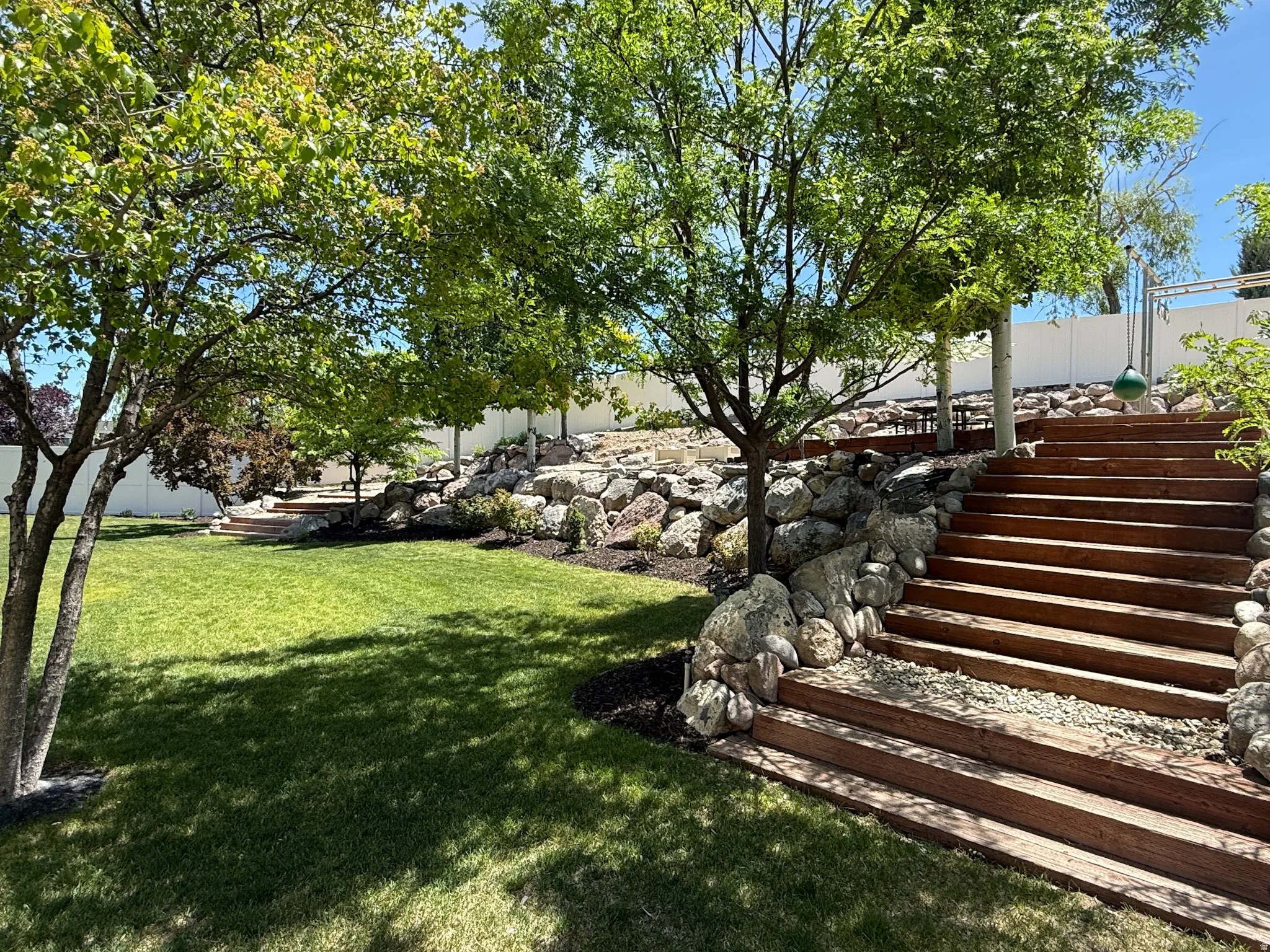 Take the wood planks to the middle terrace with permanent play/swing set that has brand new wood chips and space for covered picnic area.