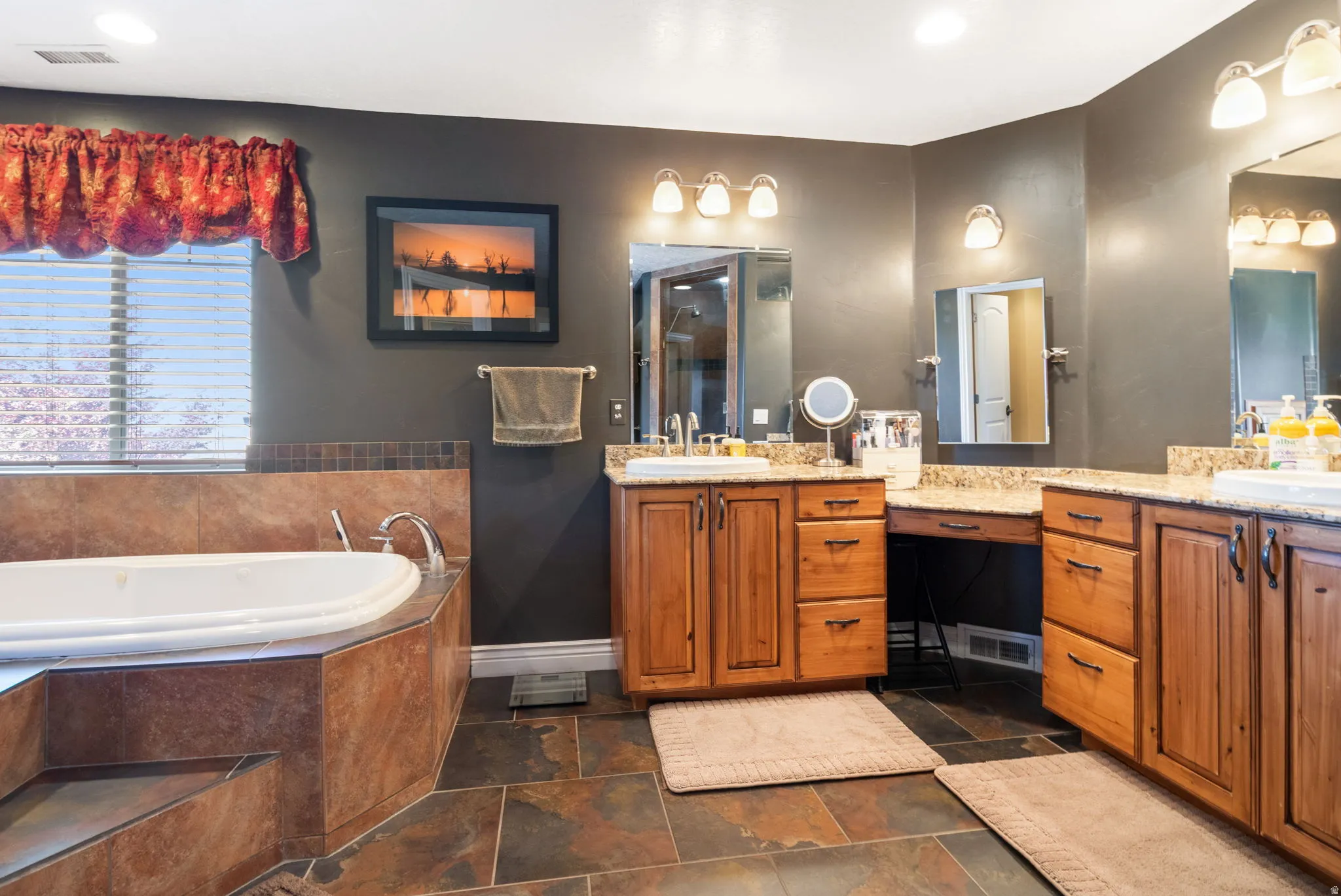 Primary bathroom with soak in tub and dual vanities.