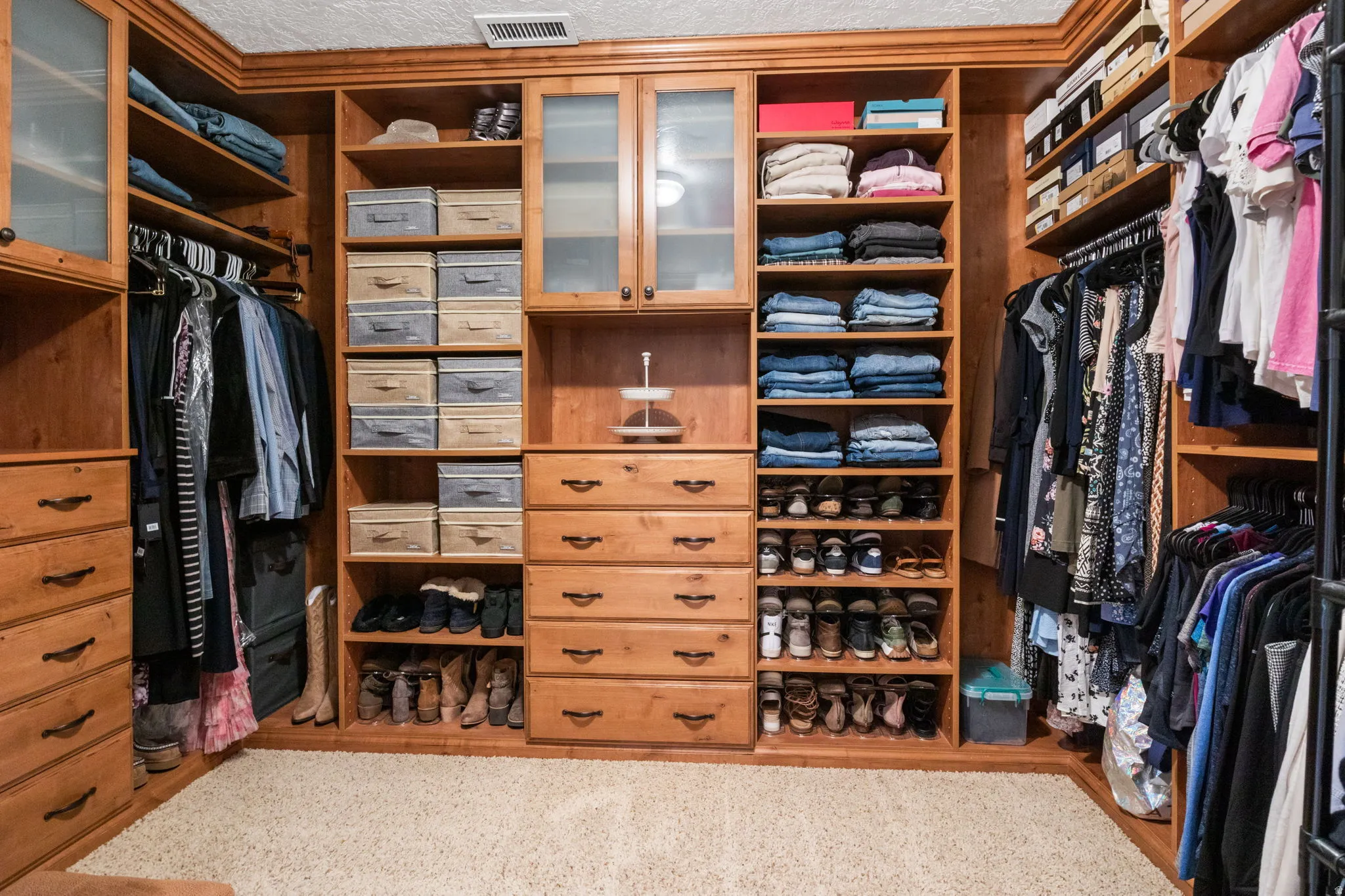 Custom wood-finish closet system featuring integrated drawers and open shelving in the primary suite.