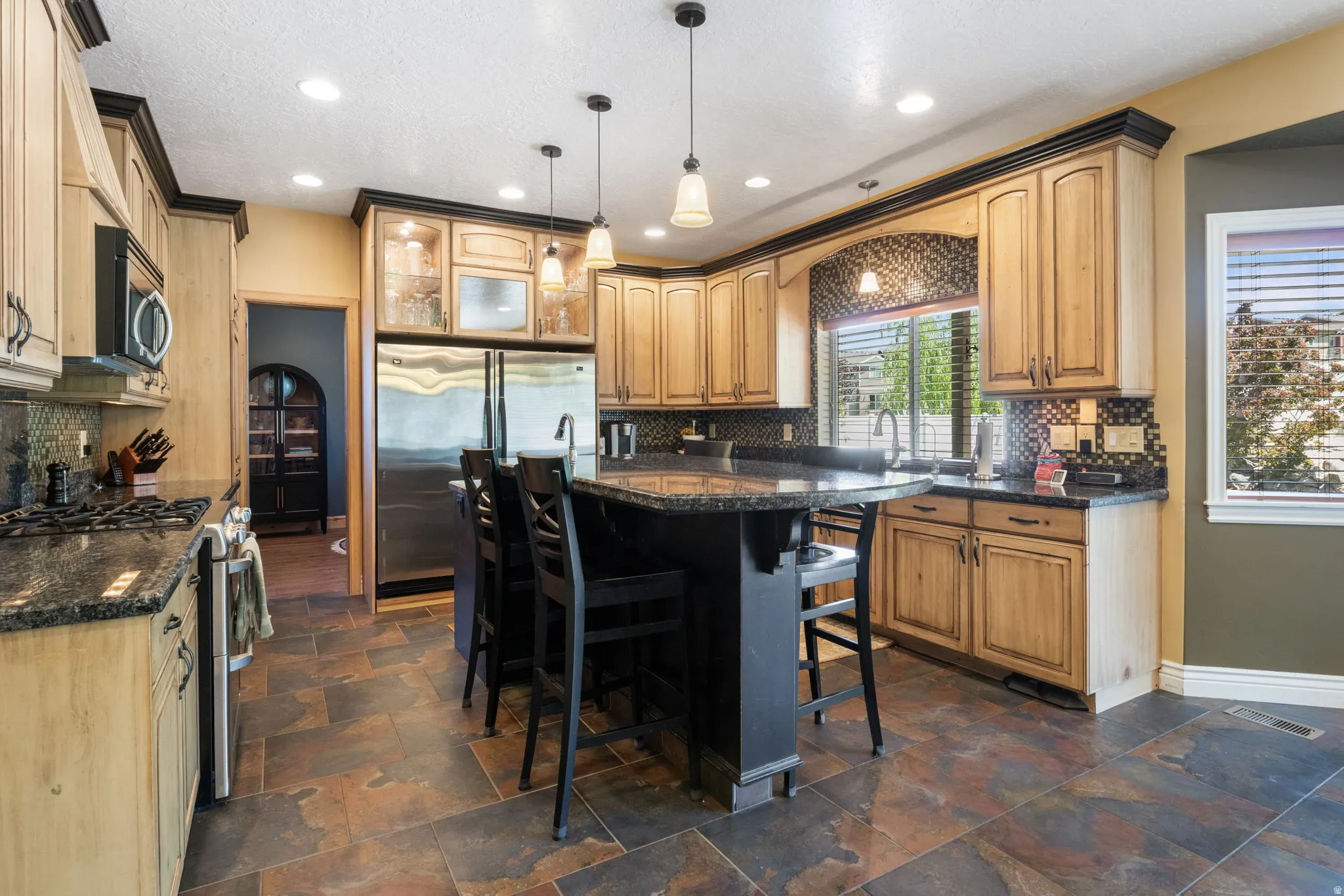 Spacious kitchen with large island, custom wood cabinetry and large 60" built in fridge.