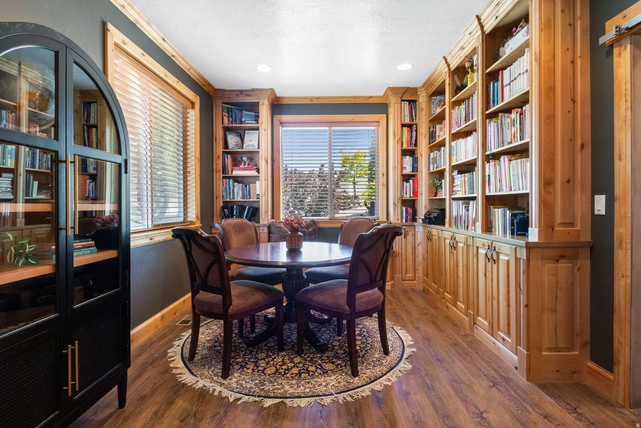 Enjoy this private study room featuring extensive built-in custom wood cabinetry and shelving