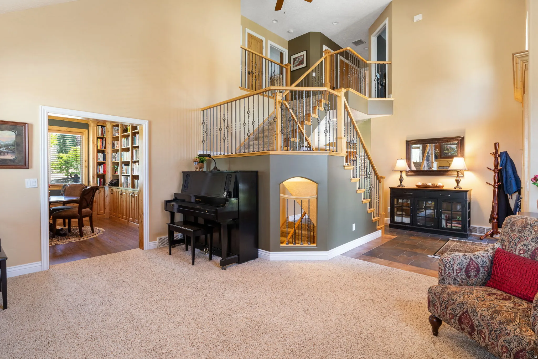 Grand two-story entry featuring wood and wrought iron staircase, high ceilings, carpeted flooring, and a tiled entry area