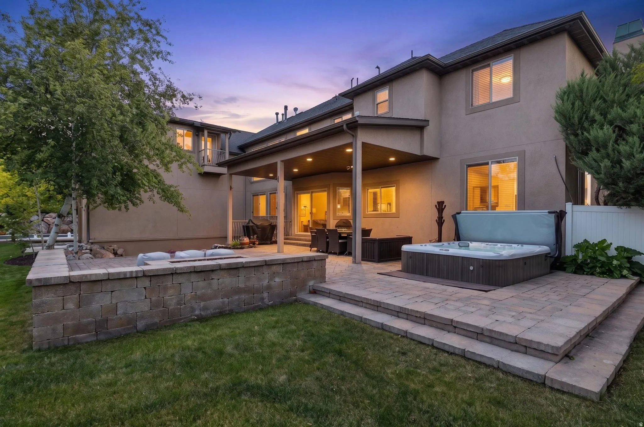 Expansive outdoor living with custom paver patio, gas fire pit and hot tub.