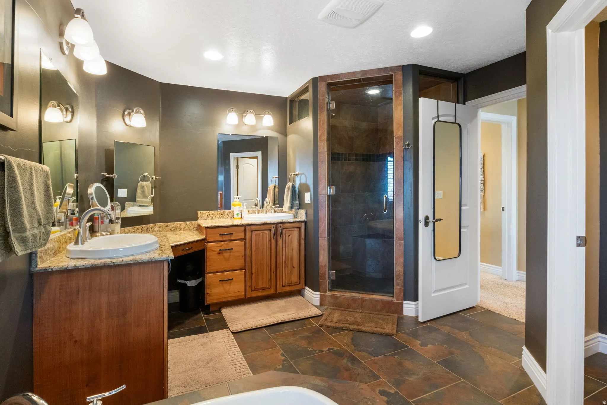 Primary bathroom with walk in shower and dual vanities.