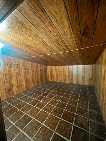Room featuring wood-finish paneling walls and ceiling, with square floor tiles
