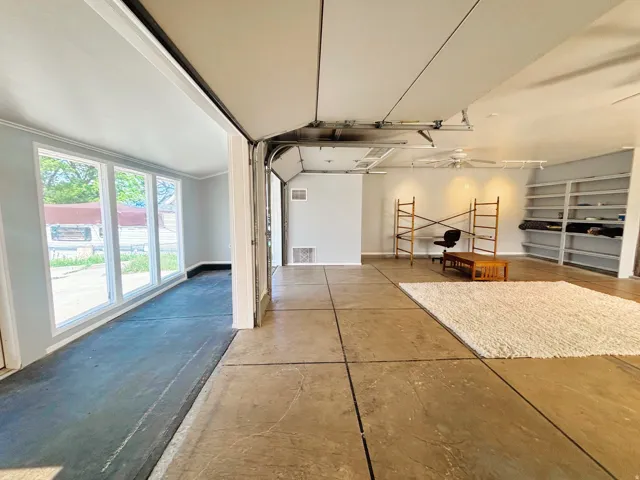 Spacious interior featuring high ceilings, concrete flooring, and extensive built-in shelving