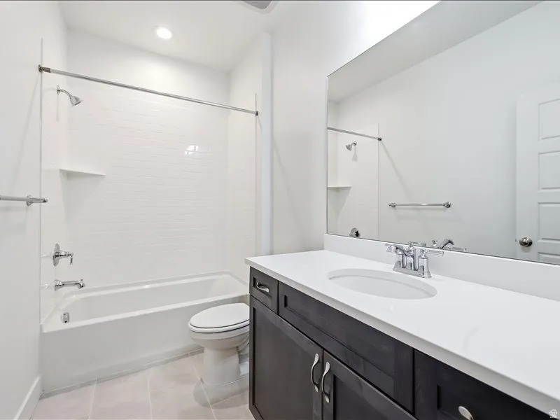 Full bathroom featuring a dark wood-finish vanity with a white countertop and integrated sink