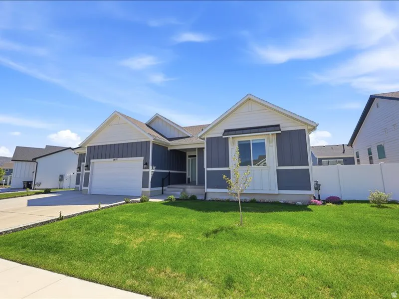Modern exterior featuring blue siding with white trim accents and a two-car garage