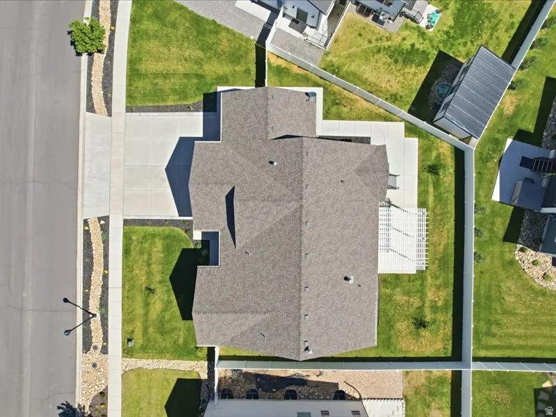 Aerial perspective highlighting the property's roofline, surrounding green space, and concrete hardscaping