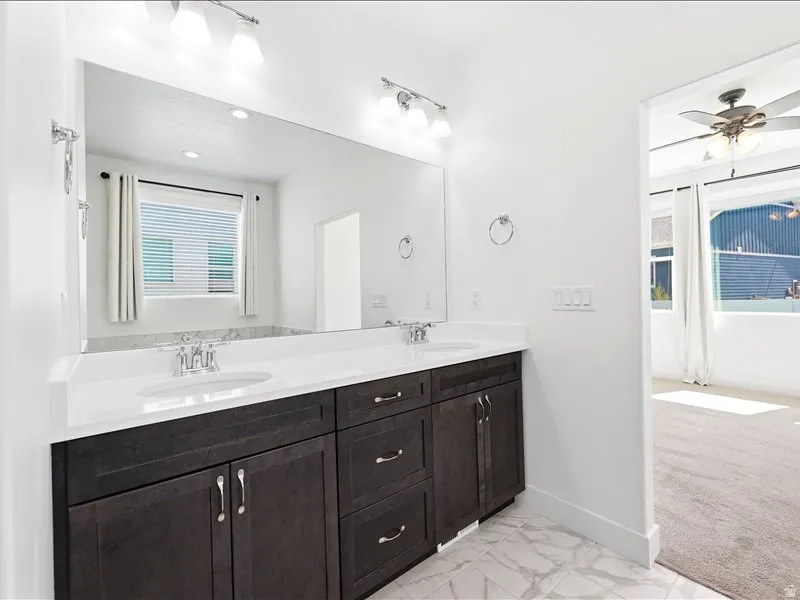 Double vanity with dark wood-finish cabinetry, white countertop, and dual undermount sinks